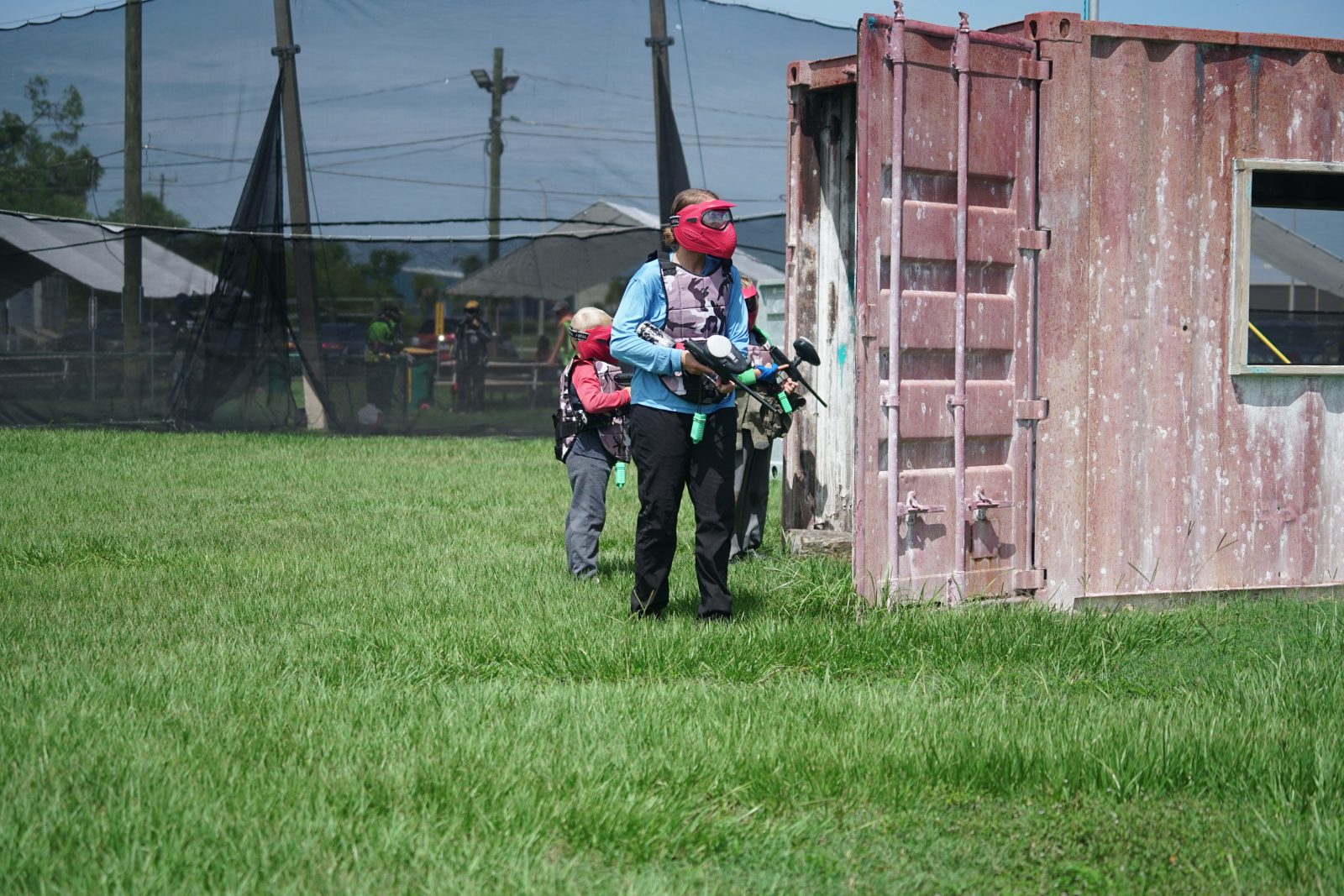 Paintball players using shipping container cover at Fort Myers Paintball Park